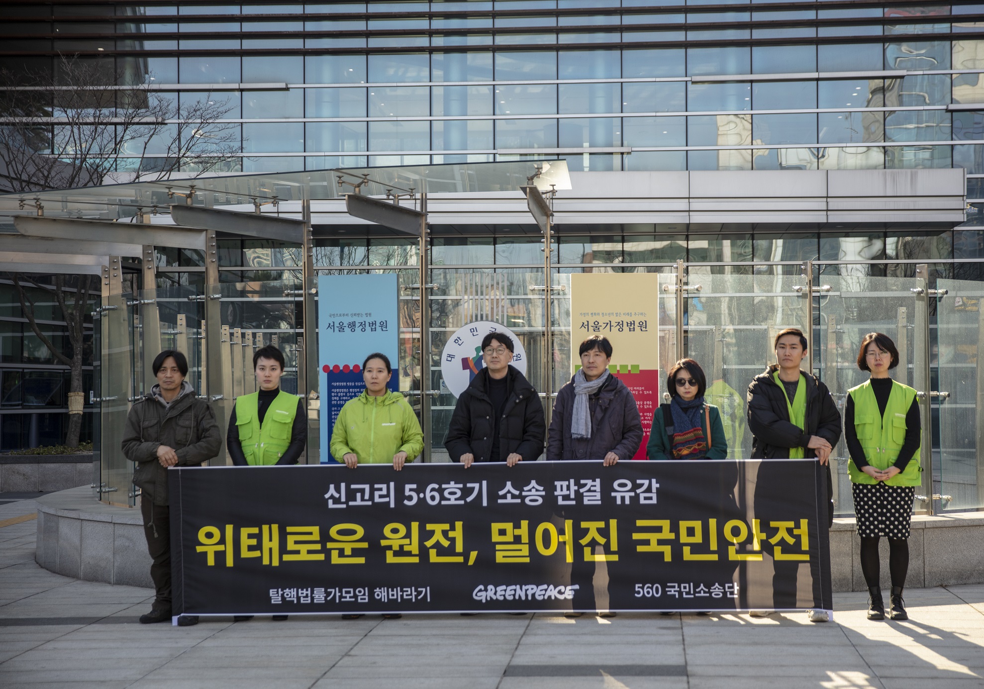 서울행정법원 앞에서 그린피스 활동가들과 560 소송단이 신고리 5,6호기 건설 허가 취소소송 사정 판결에 유감을 표하며 “위태로운 원전, 멀어진 국민안전”이라고 쓰인 배너를 들고 있다.